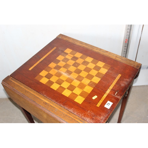 79 - An antique Sheraton style cross banded games table with slide-out square top, with chequerboard reve... 