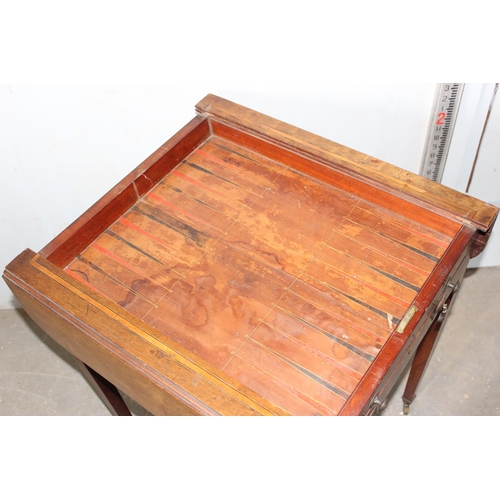 79 - An antique Sheraton style cross banded games table with slide-out square top, with chequerboard reve... 