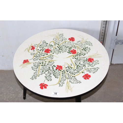 16 - A small round retro table decorated with flowers