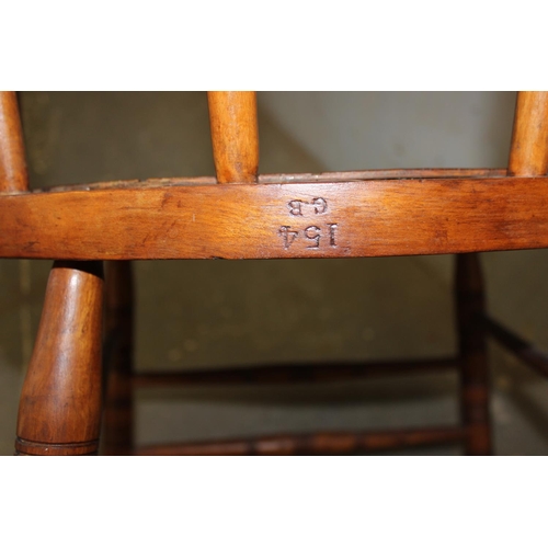 24 - An antique tub shaped wooden armchair with pierced wooden seat, stamped marks to back rail