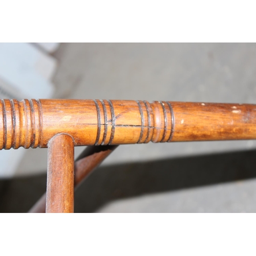 24 - An antique tub shaped wooden armchair with pierced wooden seat, stamped marks to back rail