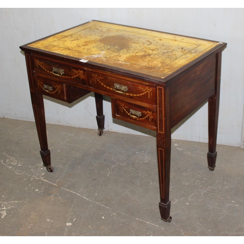 71 - An Edwardian Sheraton revival leather topped desk of small proportions with brass castors