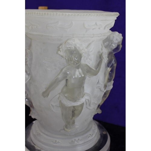 244 - An unusual Perspex table lamp formed as an urn decorated with cherubs in relief
