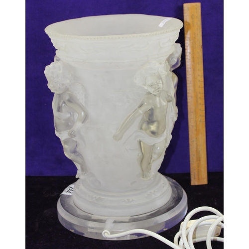 244 - An unusual Perspex table lamp formed as an urn decorated with cherubs in relief