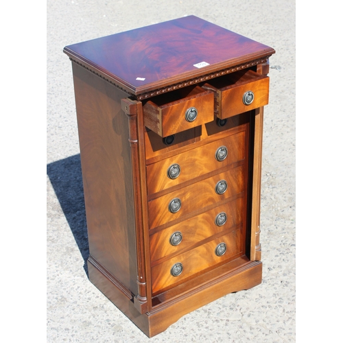 153 - A reproduction eight drawer Wellington chest with key