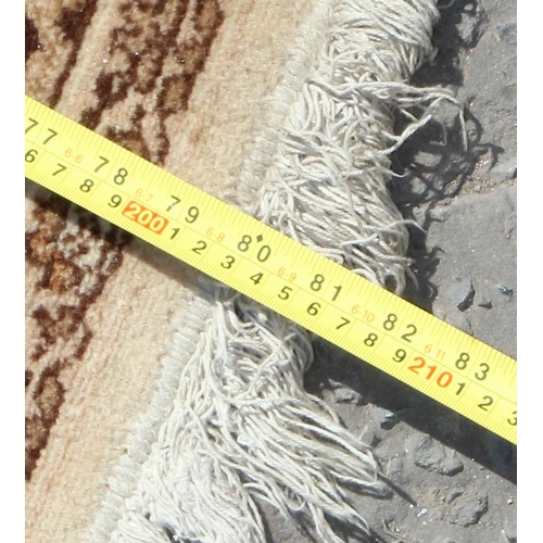 209 - Decorative cream ground rug, approx 205cm x 135cm