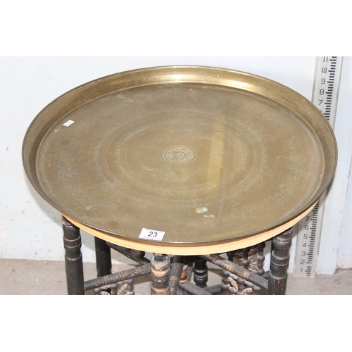 23 - A vintage Benares Bedouin type tea table with brass top and folding wooden base