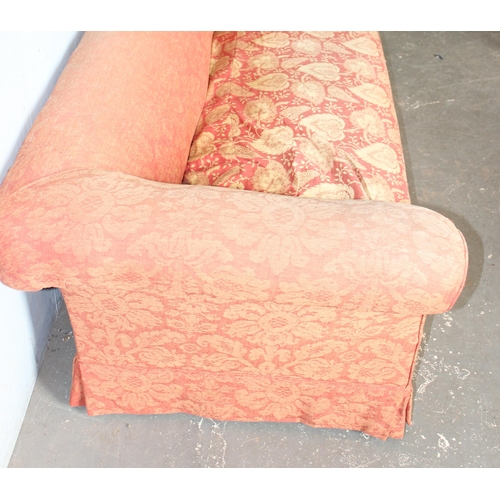 27 - An antique deep seated 2 seater sofa standing on turned wooden legs with brass and ceramic castors, ... 