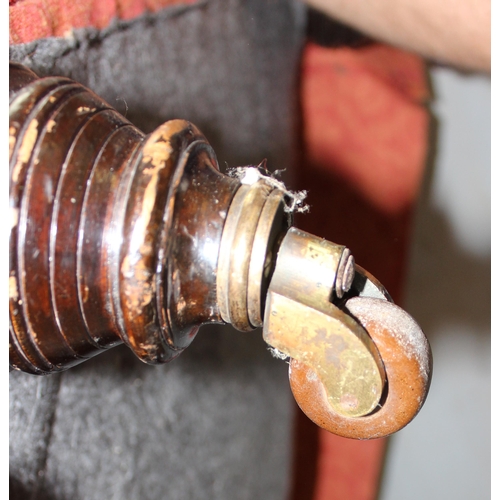 27 - An antique deep seated 2 seater sofa standing on turned wooden legs with brass and ceramic castors, ... 