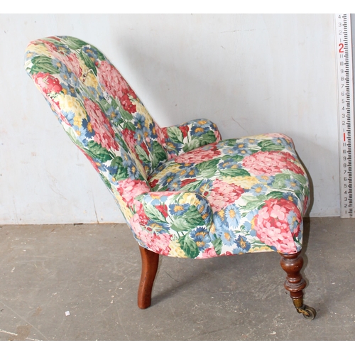 29 - An antique low chair with later floral upholstery, brass and ceramic castors stamped Cope Collinson ... 