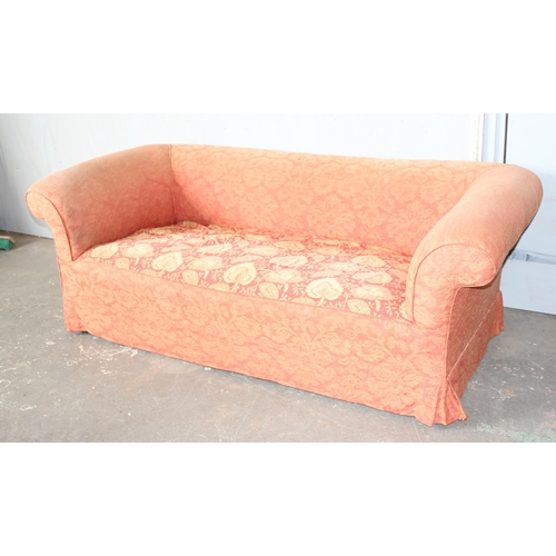 27A - An antique deep seated 2 seater sofa standing on turned wooden legs with brass and ceramic castors, ... 