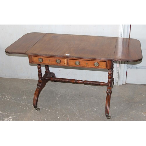 2 - A Regency mahogany sofa table, the top with hinged sides, two frieze drawers on turned end columns a... 