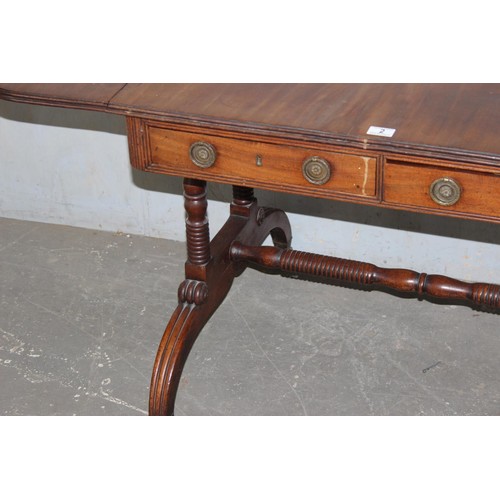 2 - A Regency mahogany sofa table, the top with hinged sides, two frieze drawers on turned end columns a... 