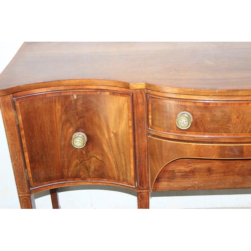 7 - A George III mahogany serpentine sideboard cross banded in kingwood, with central drawer and conceal... 