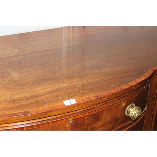 7 - A George III mahogany serpentine sideboard cross banded in kingwood, with central drawer and conceal... 