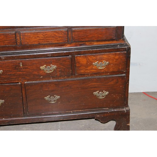 8 - An 18th century oak cabinet, enclosed by two arched panelled doors, the lower section with five draw... 