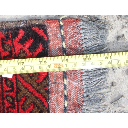 200 - A large early 20th century handmade red ground rug with various geometric patterns & 6 starburst med... 