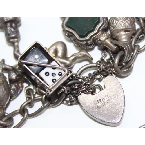 1243 - Silver charm bracelet with a large number of silver and white metal charms, approx 88.64g gross