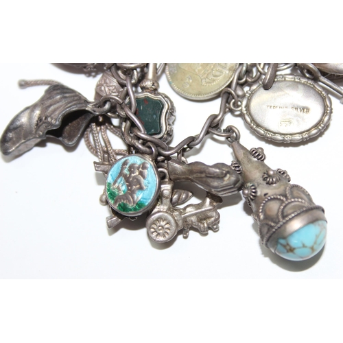 1243 - Silver charm bracelet with a large number of silver and white metal charms, approx 88.64g gross