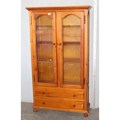 23 - Pine 2 door glazed bookcase with 2 drawers