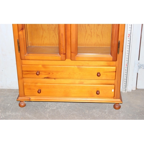 23 - Pine 2 door glazed bookcase with 2 drawers