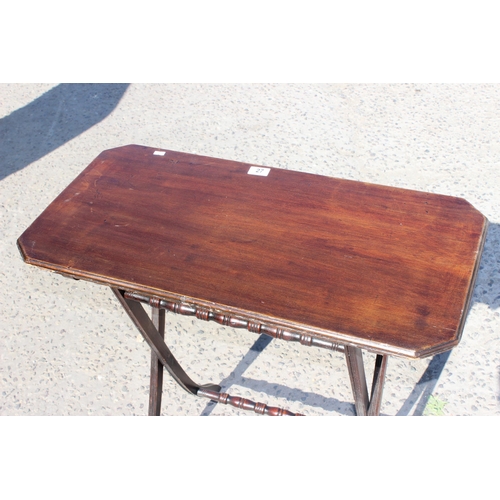 27 - A small antique mahogany folding serving table with turned stretchers