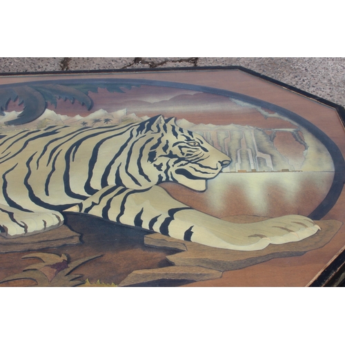 54 - An unusual large wooden and glazed coffee table formed with a fretwork scene of a Tiger