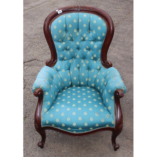 64 - An antique style low armchair with carved details and turquoise upholstery