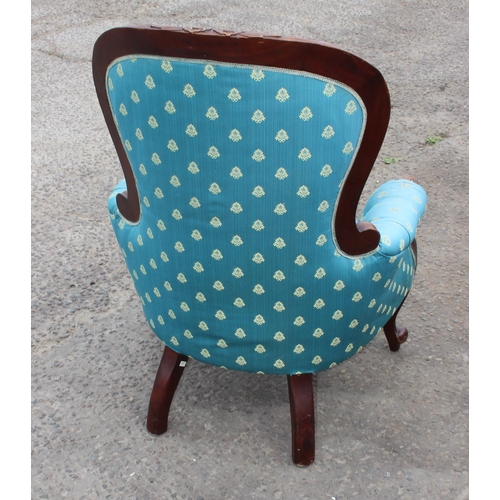 64 - An antique style low armchair with carved details and turquoise upholstery