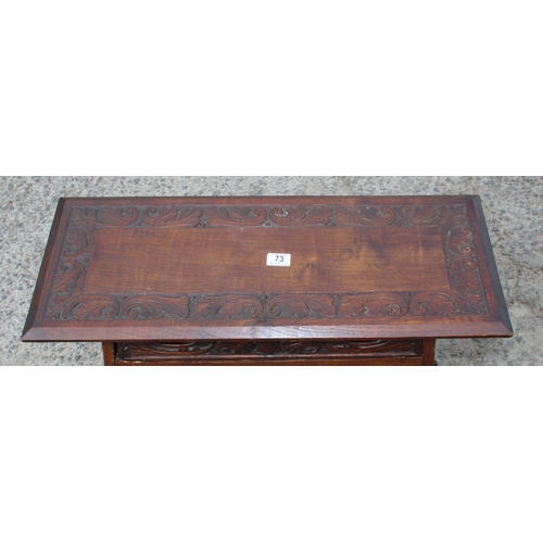 73 - An Arts & Crafts period oak table with single drawer and carved details