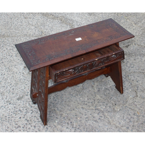 73 - An Arts & Crafts period oak table with single drawer and carved details