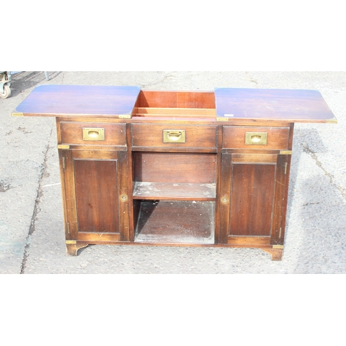 138 - A 20th century campaign style sideboard or drinks cabinet with 3 drawers over 2 cupboards and a slid... 