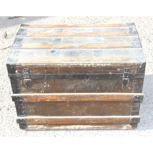 139 - An early 20th century wooden and iron bound travel trunk