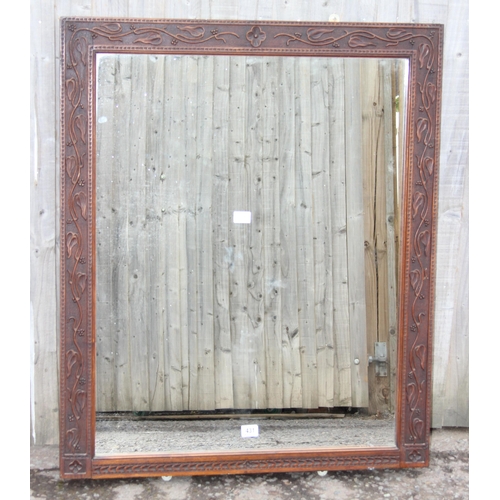 431 - A large Arts & Crafts period oak framed mirror with carved details, approx 109cm x 89cm