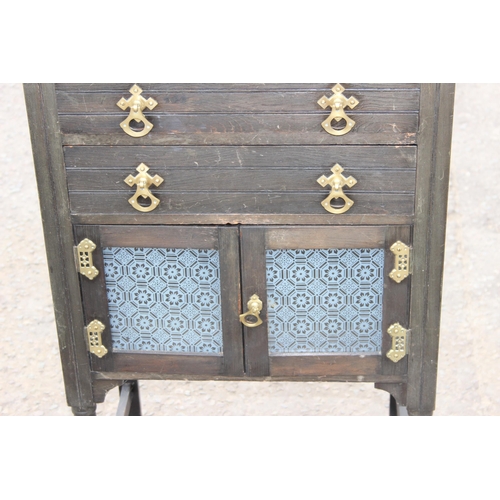 130 - An unusual antique ebonised cabinet with tile back and 2 drawers, the drawers containing 2 vintage g... 