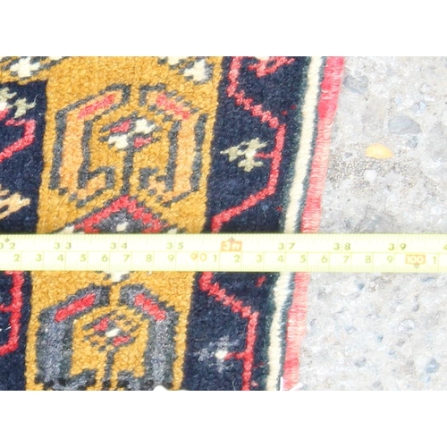 216 - A vintage hand knotted rug of blue ground with large central red medallion and yellow border, approx... 