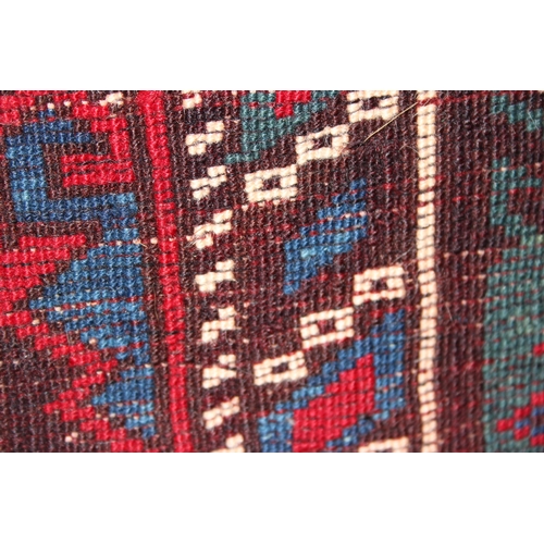 221 - A decorative vintage hand knotted rug of red and blue ground with various geometric patterns, approx... 