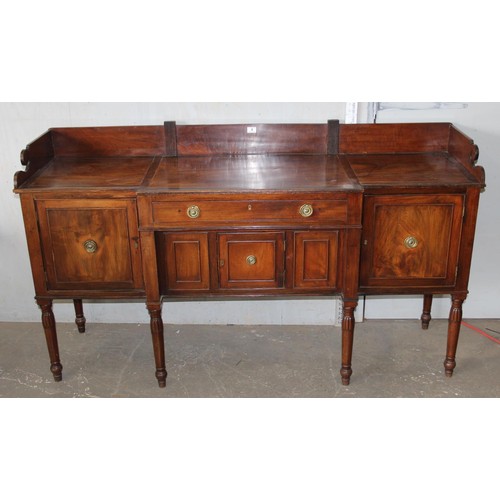 146 - An early 19th century mahogany breakfront sideboard, the galleried top above central drawer with cup... 