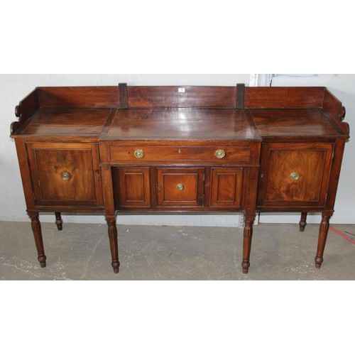 146 - An early 19th century mahogany breakfront sideboard, the galleried top above central drawer with cup... 