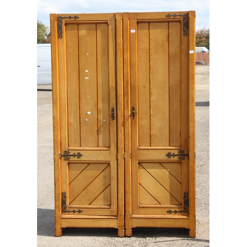 1 - A large vintage pine wardrobe with gothic style strapwork hinges, the interior containing shelves an... 