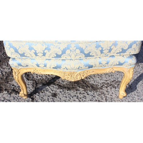 100 - A pair of French style high backed armchairs with carved giltwood frame and blue & gold upholstery, ... 