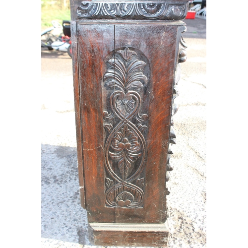 102 - An antique carved dark oak bookcase in the Jacobean style, approx 110cm tall x 94cm wide