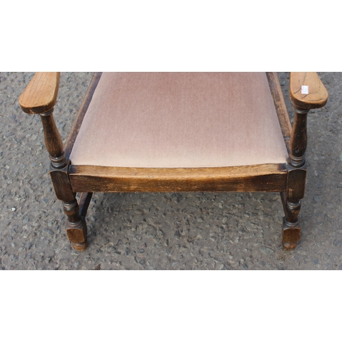 88 - A vintage low oak armchair with matching stool with carved details (2)