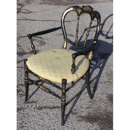 98 - An antique ebonised armchair with gilt floral decoration