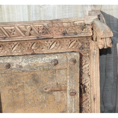 227 - A rustic wooden window shutter with iron fittings and carved details