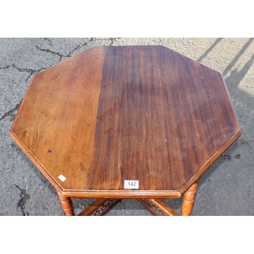 142 - A late Victorian mahogany octagonal table standing on brass and ceramic castors with Aesthetic Movem... 