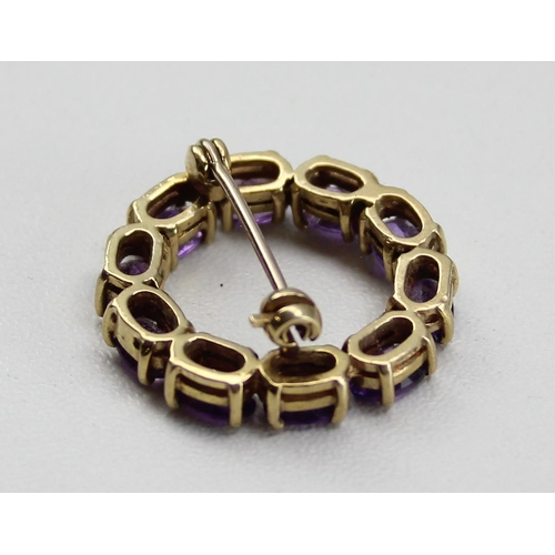 1230 - 9ct gold and amethyst brooch set in a circular pattern, hallmarked for 9ct gold, approx 4.99g gross