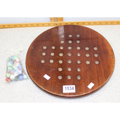 1534 - A vintage wooden solitaire board with glass marbles