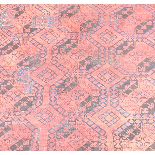 154 - A large red ground Afghan rug decorated with gul, approx 310cm x 220cm