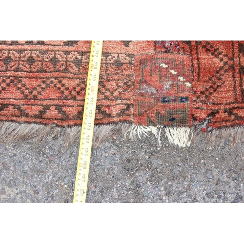 154 - A large red ground Afghan rug decorated with gul, approx 310cm x 220cm